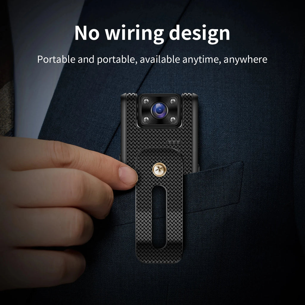 Small black carbon-fiber-textured wearable camera with a metal pocket clip attached to a suit jacket.