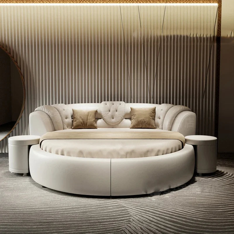 Modern cream-coloured round double bed with a tufted, curved headboard and two matching integrated bedside tables.