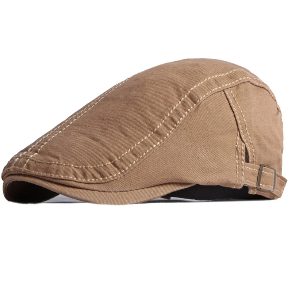 A tan cotton flat cap with stitched panel detailing and an adjustable side buckle strap.