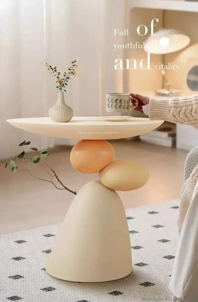 Minimalist cream-coloured side table featuring a unique sculptural base of stacked rounded shapes.