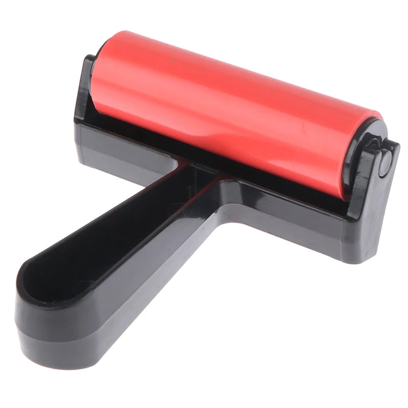 Red craft roller with a smooth rubber barrel and a sturdy black plastic handle for printing and paper crafting.