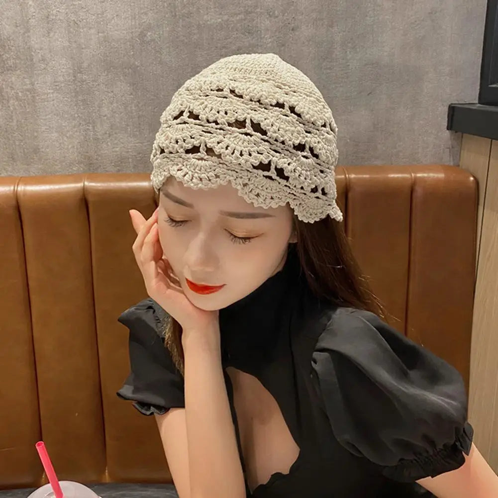 Cream-coloured women's crochet lace beanie with an intricate hollow floral pattern and a scalloped edge.