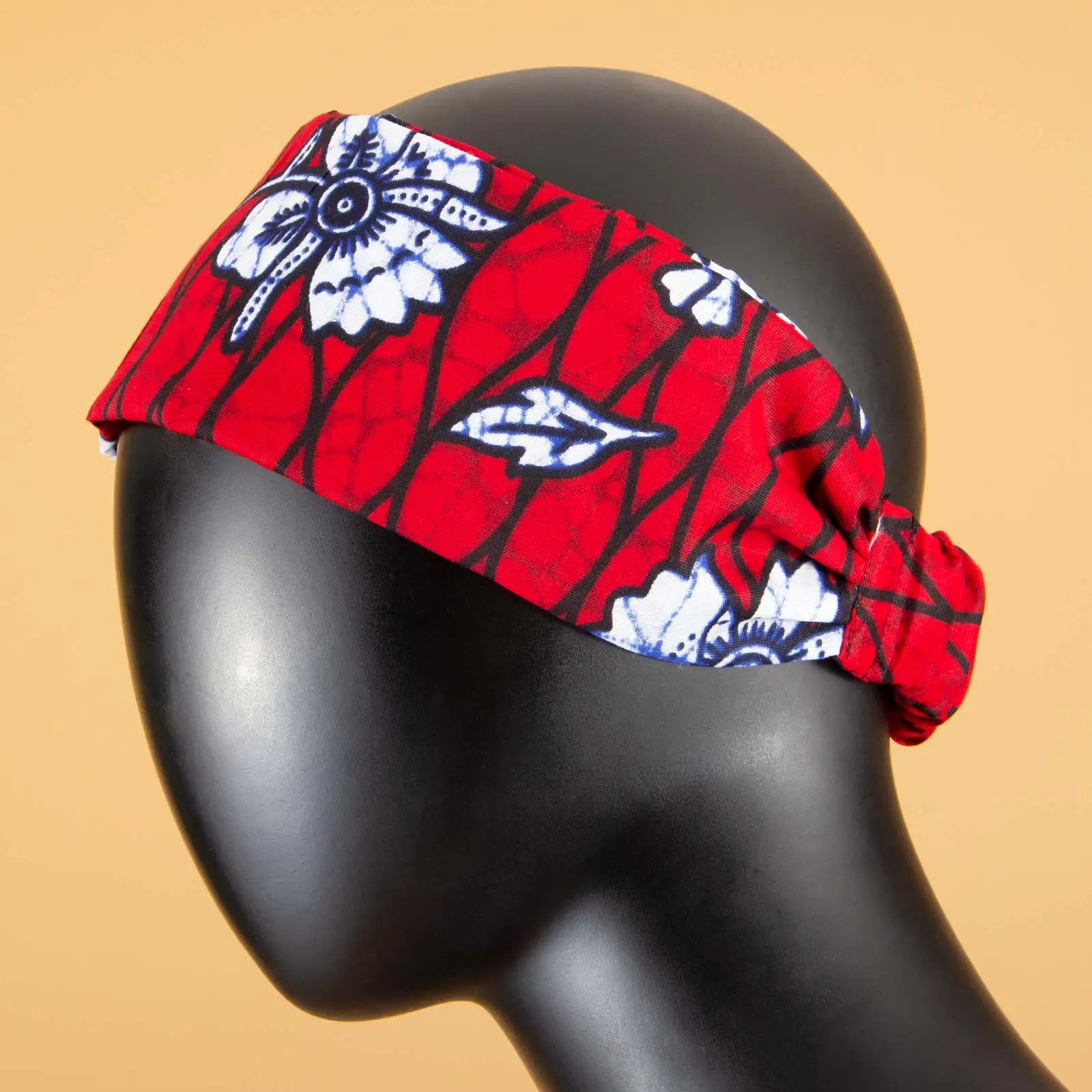 Red elasticated fabric headband with a white and black floral botanical print on a black mannequin head.