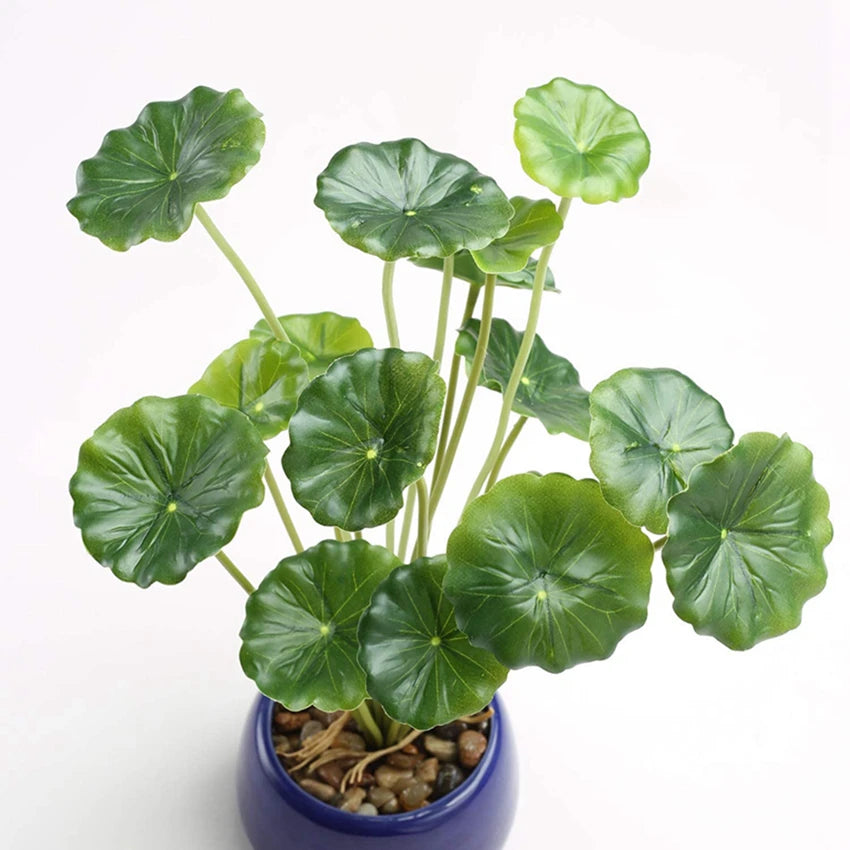 Artificial lotus plant with scalloped green leaves in a small, round blue pot filled with decorative river stones.