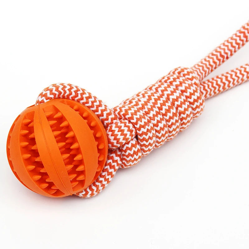 Durable orange rubber spiky treat ball attached to a thick, chevron-patterned orange and white braided rope toy.