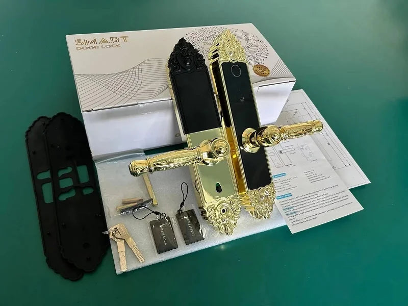 Gold and black metal smart door lock with biometric fingerprint scanner, keys, and access cards in its original box.