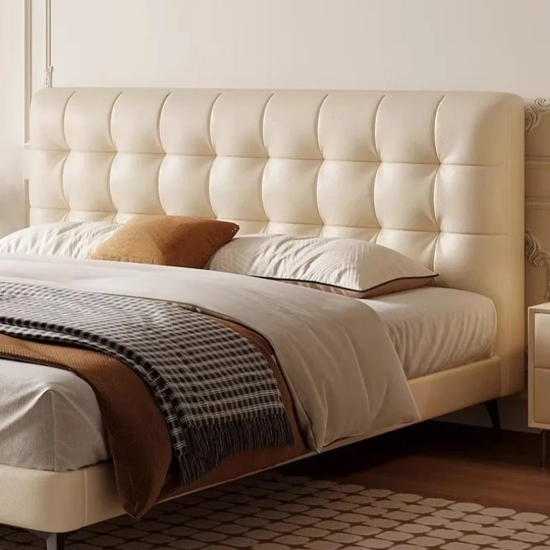 Minimalist cream bed frame with a large, tufted upholstered headboard and low-profile wooden base.