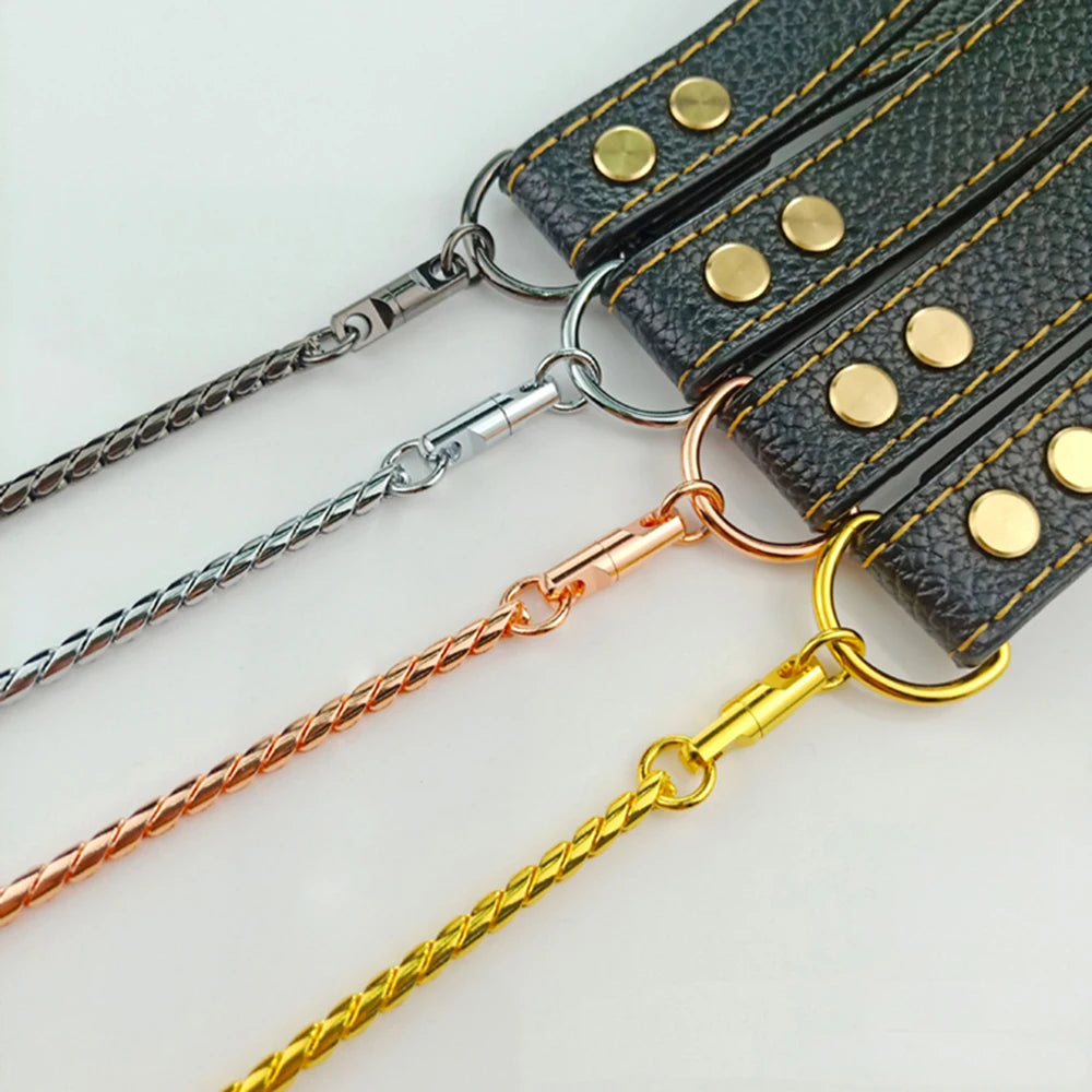 Four metal dog leashes with black leather handles, gold rivets, and black, silver, rose gold, and gold chains.