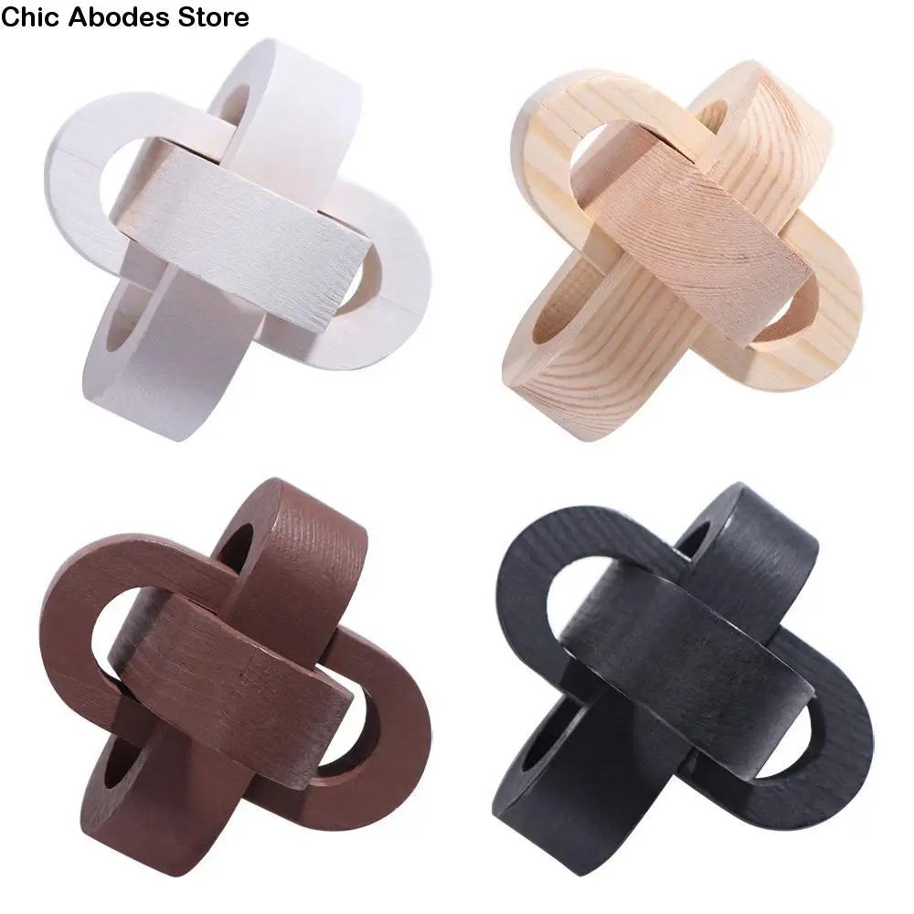 Four geometric wooden decorative chain link sculptures in white, natural, brown, and black.