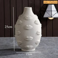 Off-white ceramic vase featuring an embossed, all-over lip pattern. Measures 17cm wide by 25cm tall.
