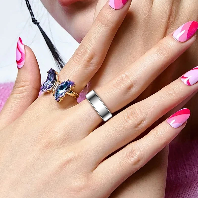A person wearing a sleek, silver-toned minimalist smart fitness ring on their finger.