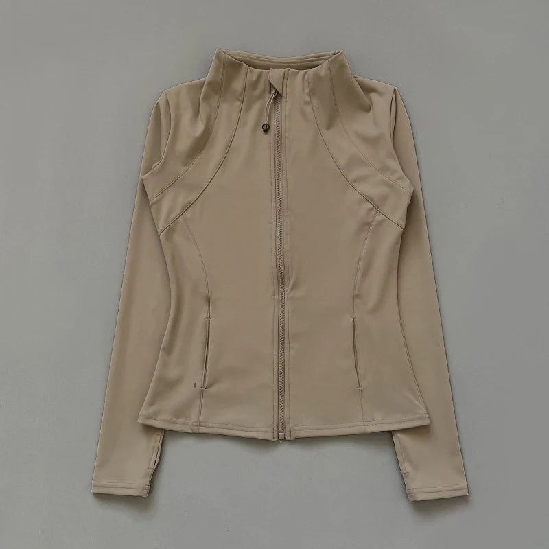 Beige fitted zip-up sports jacket with a high neck, long sleeves, and side pockets against a grey background.