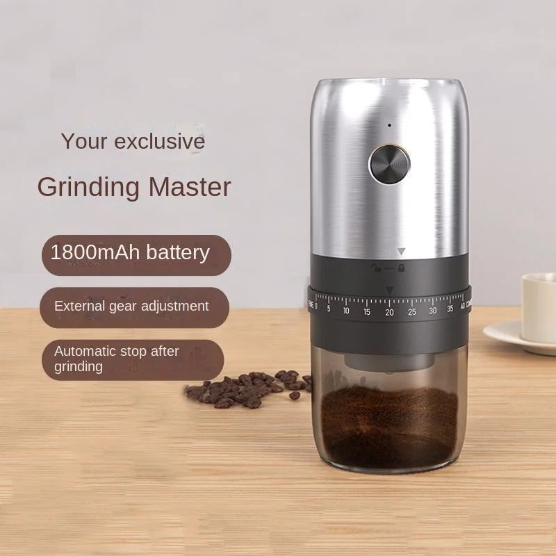 Cylindrical silver and black electric coffee grinder with an external numbered adjustment dial and clear base.