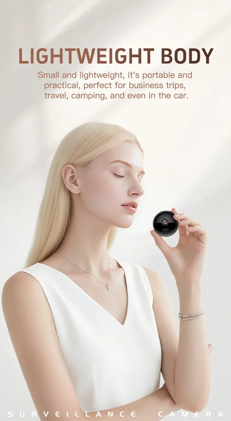 A woman holding a small, black, circular wireless 4K security camera in her palm.