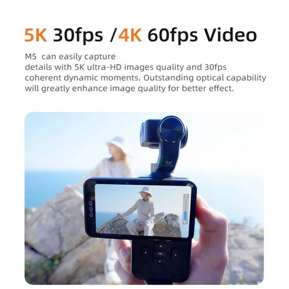 Black plastic handheld digital gimbal camera with a 5K display screen showing a person at the beach.