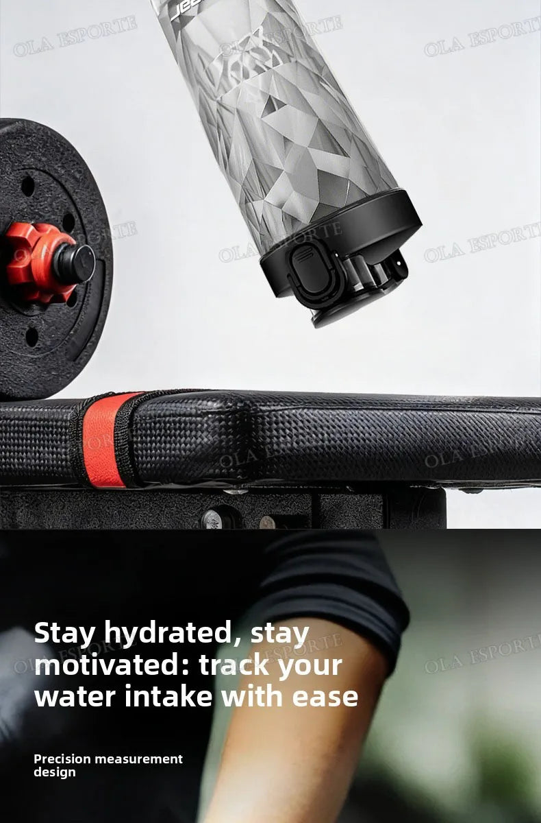 A silver, geometric-patterned water bottle with a black lid, positioned above a workout bench and dumbbell.