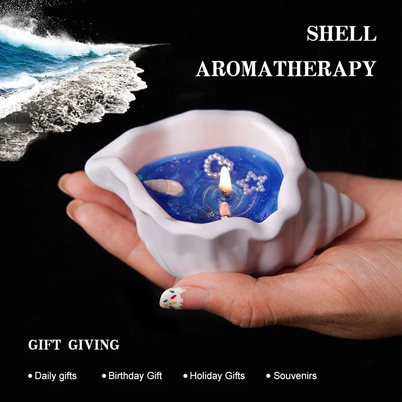 White shell-shaped candle with blue wax, featuring pearl-like star and shell accents, held in hand.