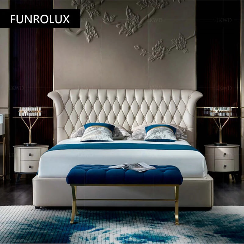 Luxury cream leather double bed with a button-tufted, flared headboard and a matching navy blue velvet storage bench.