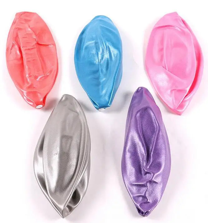 Five deflated metallic peanut exercise balls in red, blue, pink, silver, and purple on a white background.