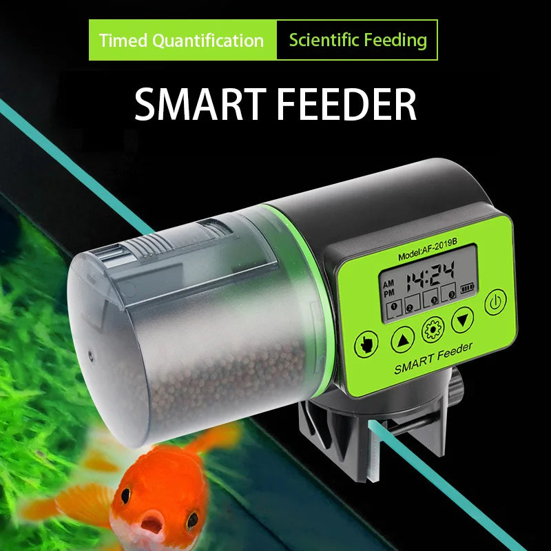 Black and green digital automatic fish feeder with a transparent food hopper, mounted on a glass aquarium edge.