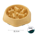 Beige slow-feeder pet bowl with internal bone-shaped obstacles for eating, 22.5cm diameter, includes anti-slip pads.