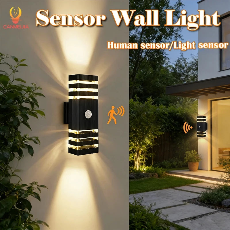 Modern black rectangular outdoor LED wall light with motion sensor, casting warm up-and-down light beams.