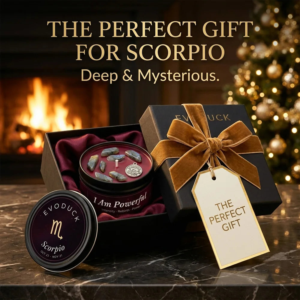 Scorpio zodiac candle gift set with crystals and charm in a black box with gold ribbon, set against a fireplace.