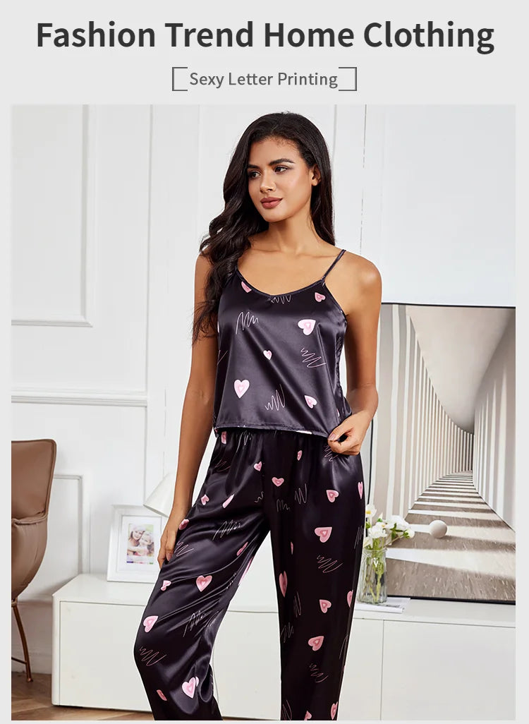 Black satin pajama set featuring pink heart prints and thin spaghetti straps, perfect for stylish loungewear.