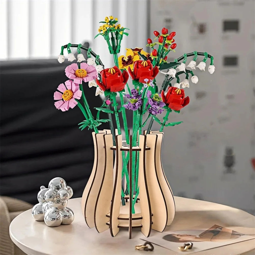 A colourful buildable brick flower bouquet with red, pink, and white blossoms in a modern, slatted light wooden vase.