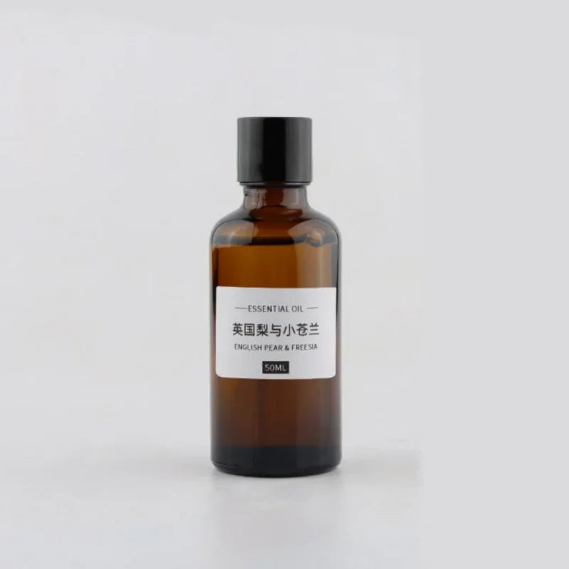 50ml amber glass bottle of English Pear & Freesia essential oil with a simple white label and black cap.