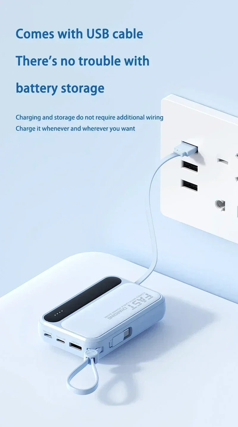 Compact light-blue power bank with built-in USB charging cable plugged into a wall socket.