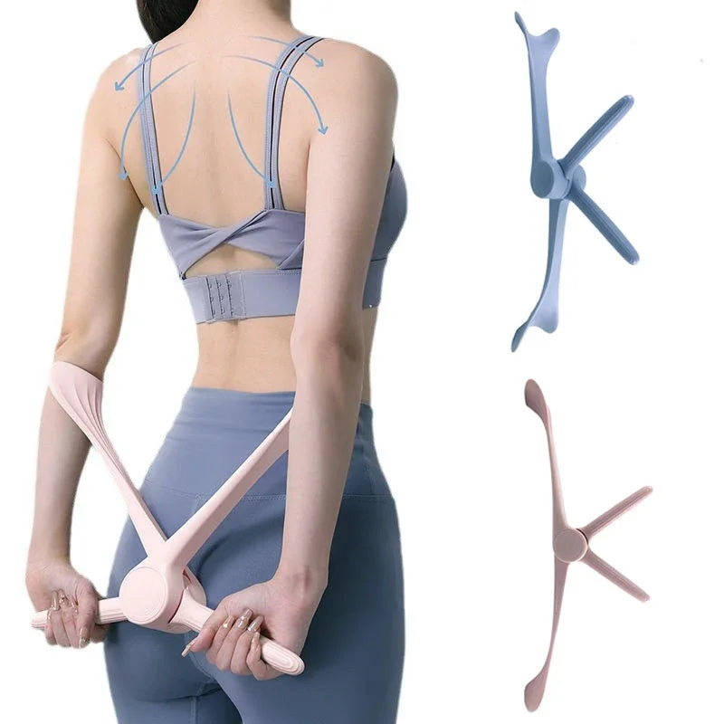 A woman in gym wear using a pink, three-armed, handheld yoga fitness tool to exercise her arms and back.