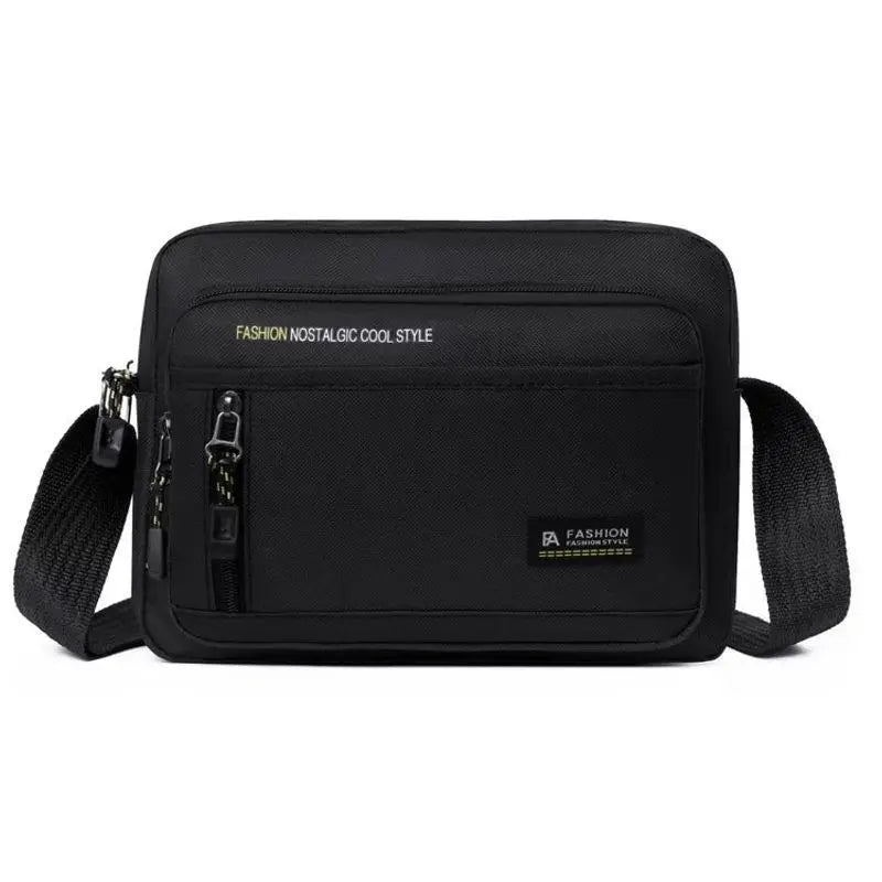 A black, rectangular men's crossbody bag with an adjustable strap, multiple zipped compartments and a sleek finish.