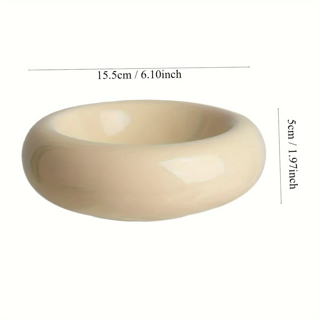 Cream-coloured ceramic cat bowl with a wide, minimalist rounded design. Dimensions shown: 15.5cm wide, 5cm high.