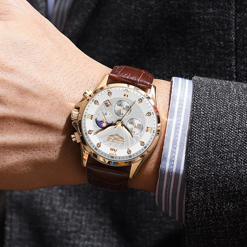 Men’s gold-tone chronograph watch with a textured white dial, moon phase display, and brown leather strap on a wrist.