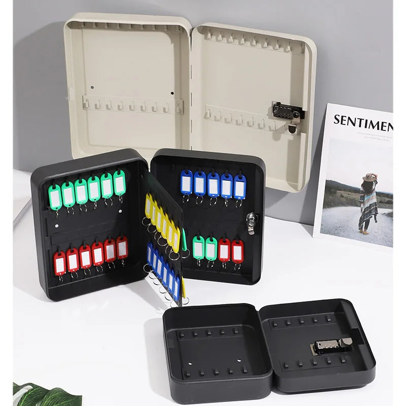 Black and beige metal wall-mounted key cabinets with combination locks and various colored key tags.