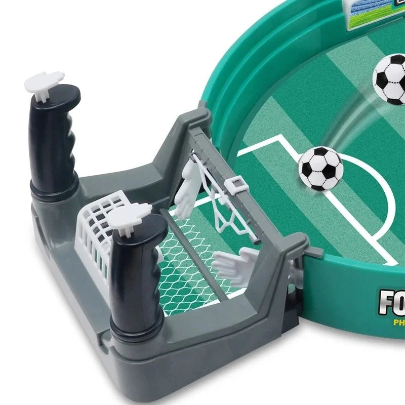 Tabletop football game featuring a green pitch, two white soccer balls, and grey goal structure with manual controllers.