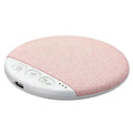 Round, blush-pink fabric under-pillow speaker with a white control panel, buttons, and USB charging port.