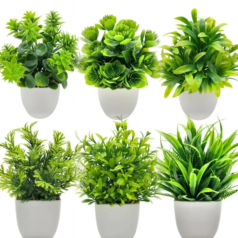 Six assorted artificial green plants in simple white pots, arranged in two rows against a white background.