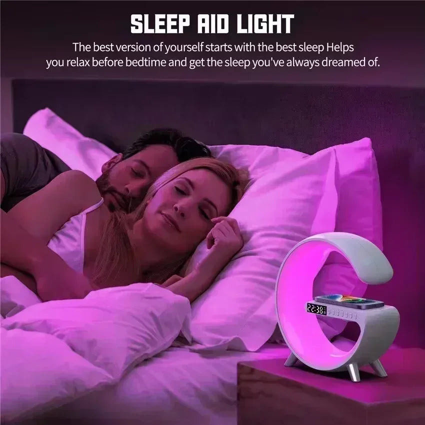 A white C-shaped wireless charging stand with a built-in alarm clock, glowing with ambient pink light on a bedside.