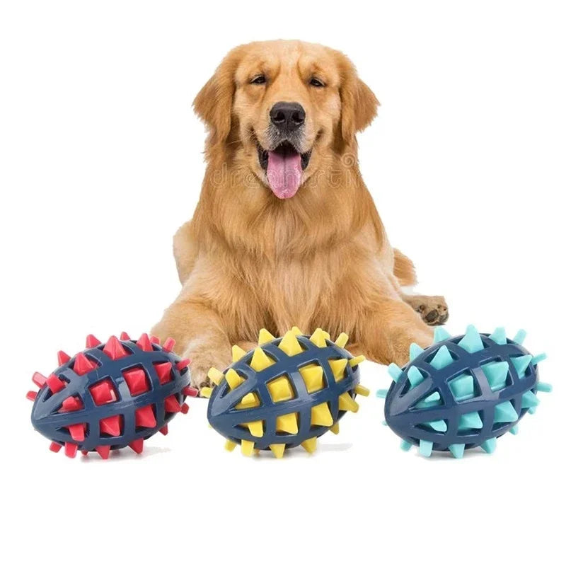 A happy Golden Retriever behind three durable, spiky rubber rugby ball dog toys in red, yellow, and light blue.