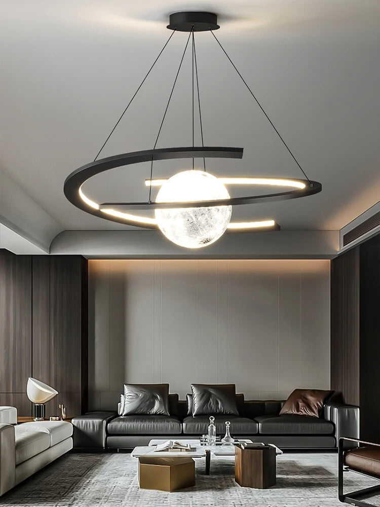 Modern black pendant lamp with a glowing central orb and circular LED ring, suspended in a contemporary living room.