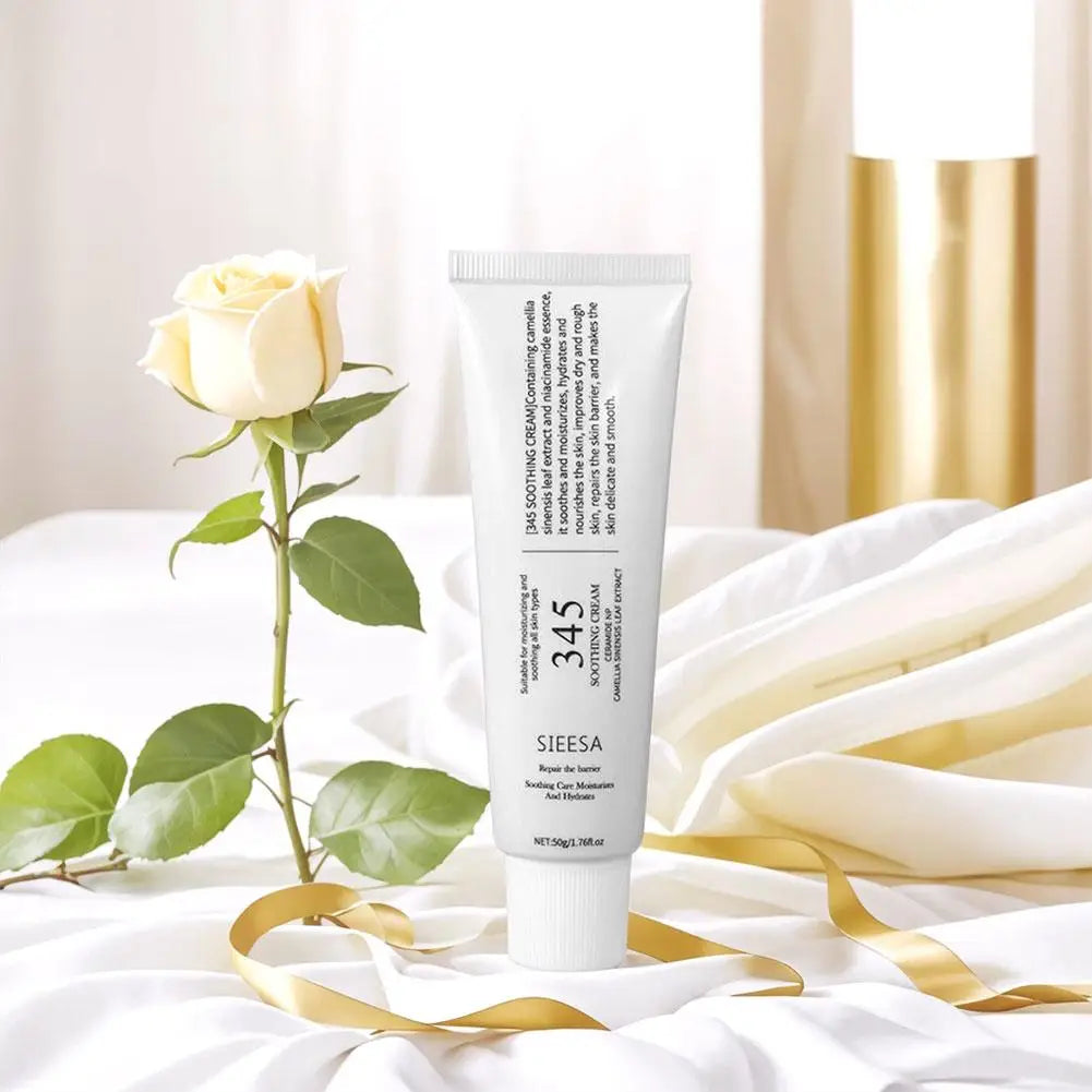 White soothing cream tube in elegant, minimalist packaging, styled with a cream rose and gold ribbon.