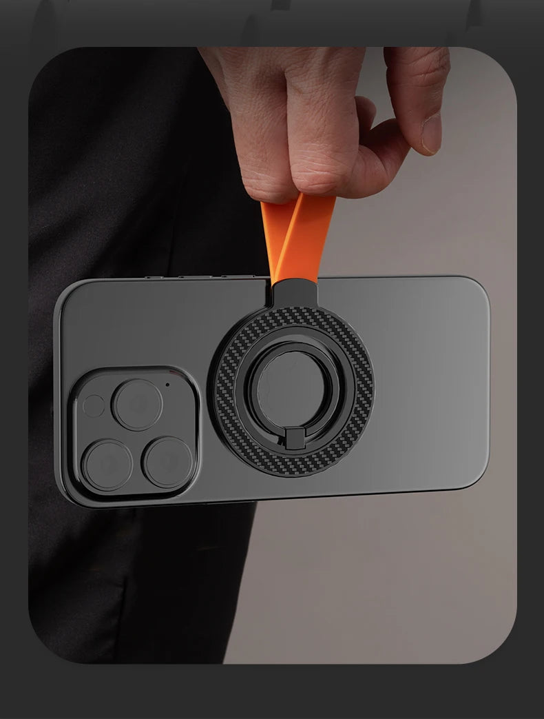 Black smartphone case with a carbon-fiber textured magnetic ring stand and a vibrant orange finger strap.