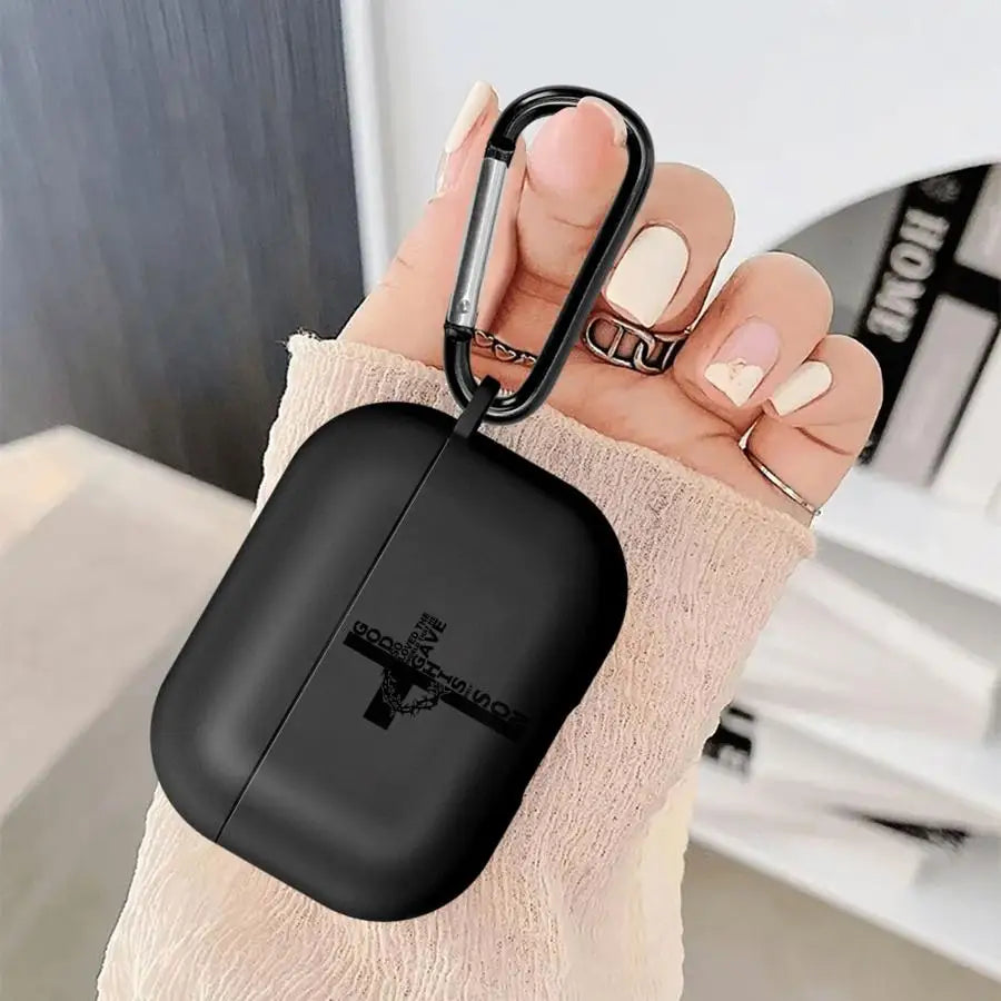 Black matte silicone AirPods Pro case with religious cross print and black carabiner held in hand.