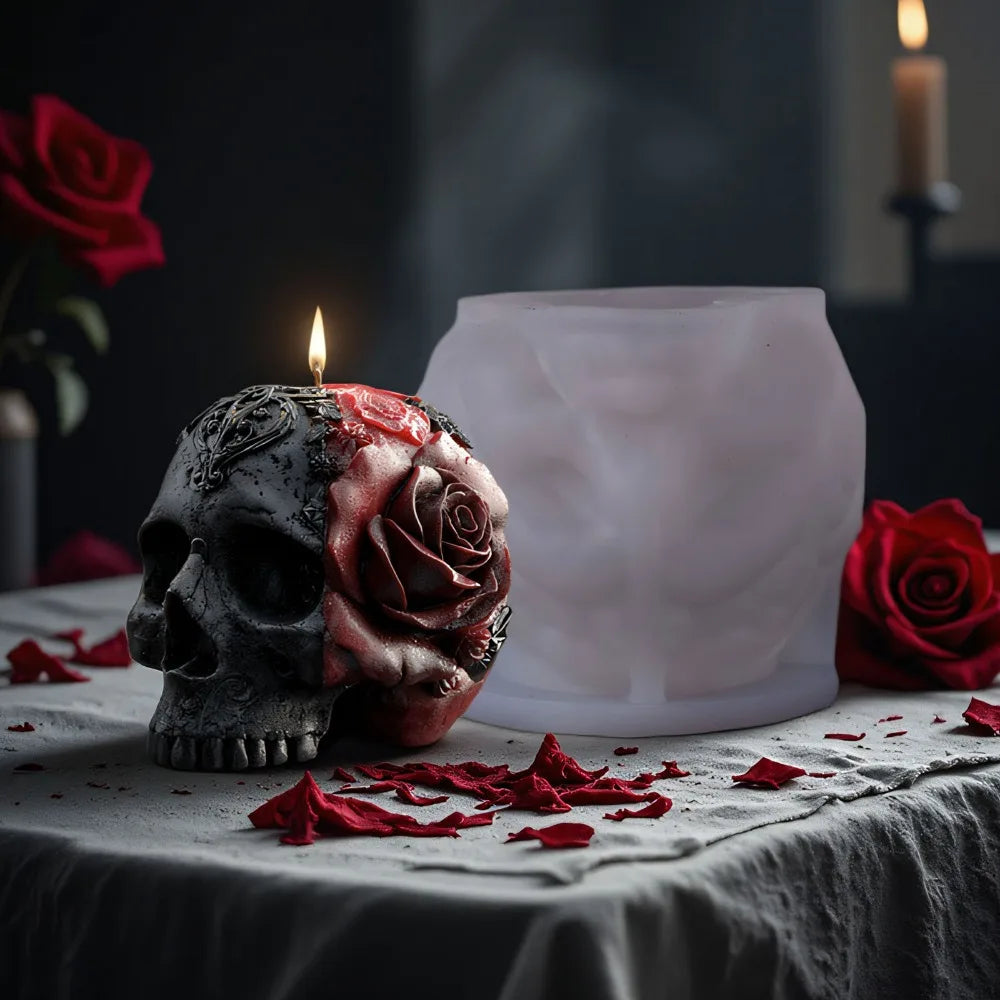 Grey and red skull candle with a sculpted rose and filigree, next to a translucent silicone mold.