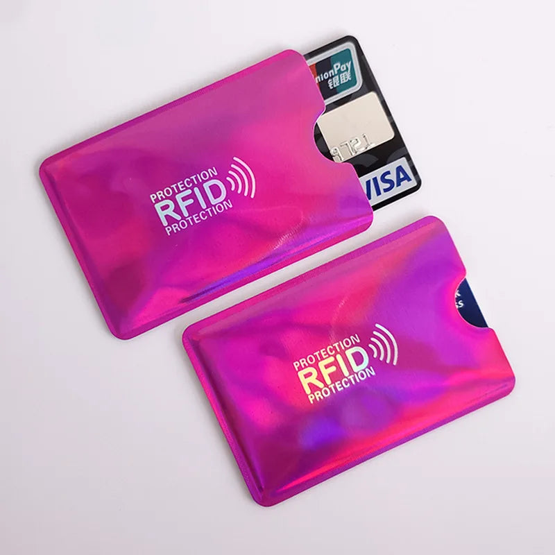Two shiny pink holographic RFID-blocking credit card sleeves holding bank cards.