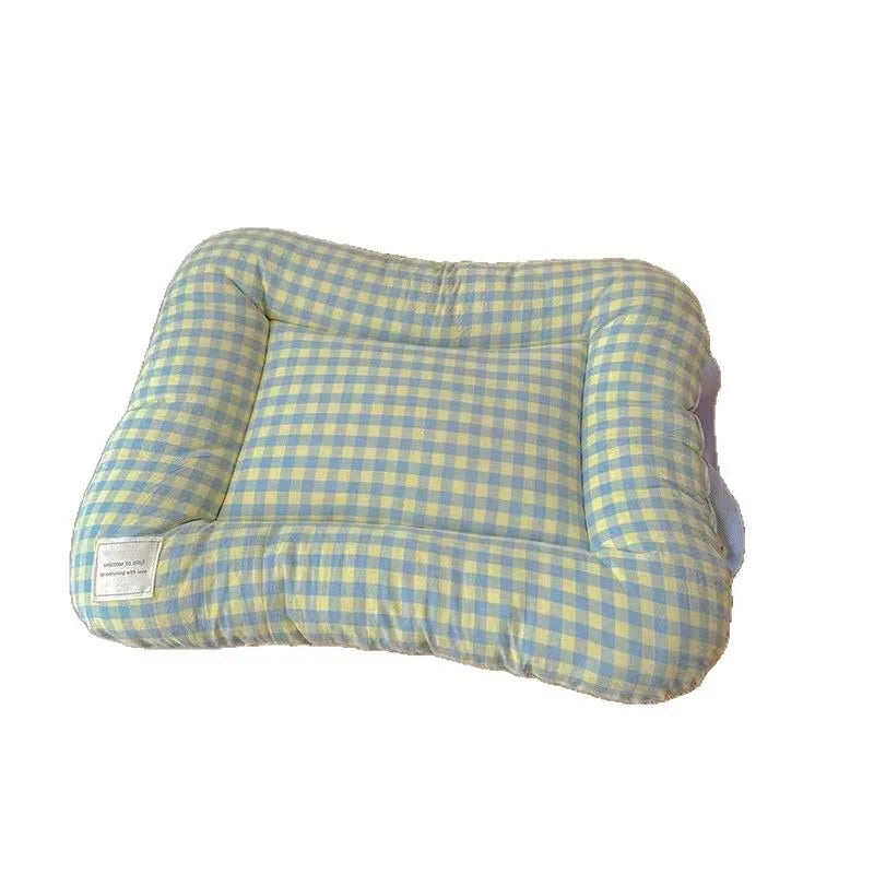 Soft rectangular pet bed in yellow and blue plaid with raised bolsters and a small white brand label on the corner.