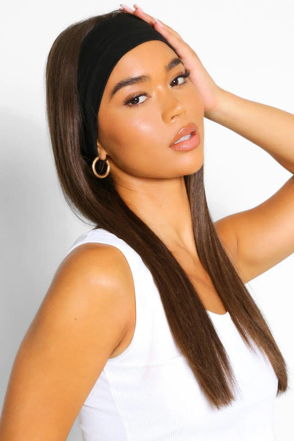 A woman with long brown hair wearing a wide, plain black fabric headband.