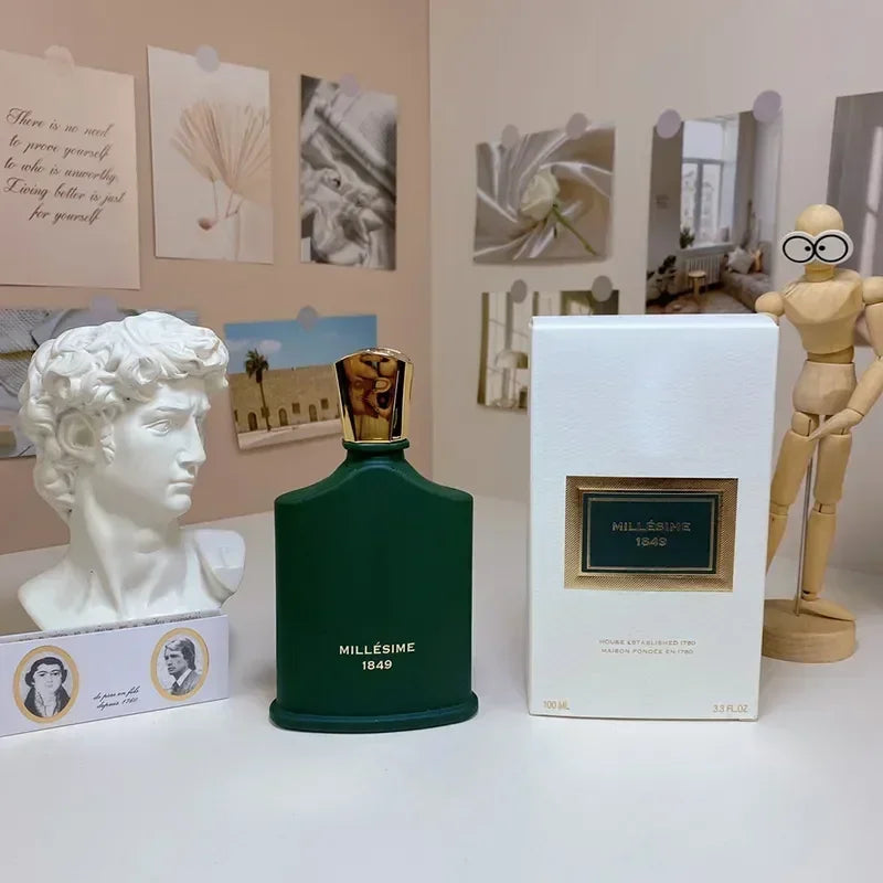 Dark green Millésime 1849 perfume bottle with gold cap, next to its white box, David bust, and mannequin.